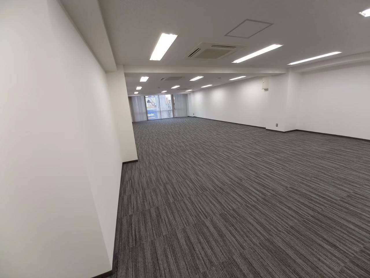 タイルカーペットの施工が完了した、明るく広いオフィスフロア